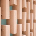 Close-up of a wooden acoustic diffuser wall with staggered blocks